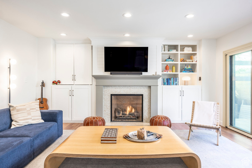 Living room featuring a lit fireplace, recessed lighting, and wood finished floors