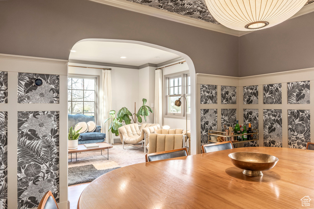 Dining space featuring arched walkways and ornamental molding