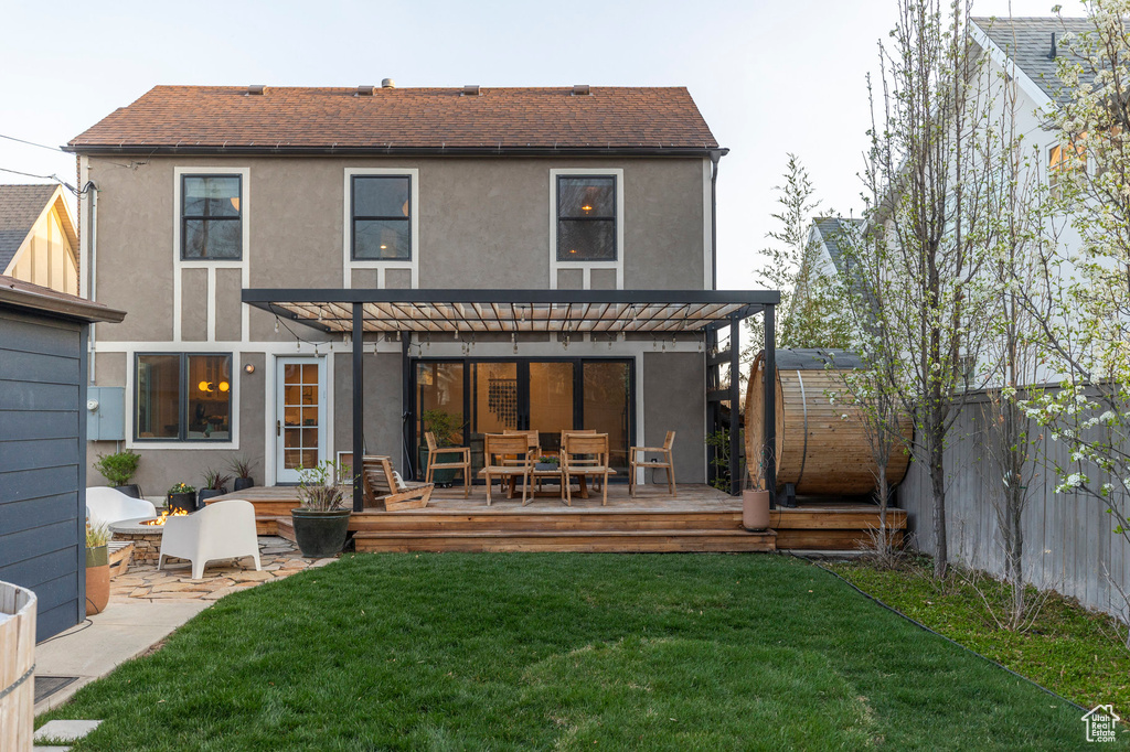 Back of house with a fenced backyard, a pergola, stucco siding, and a deck