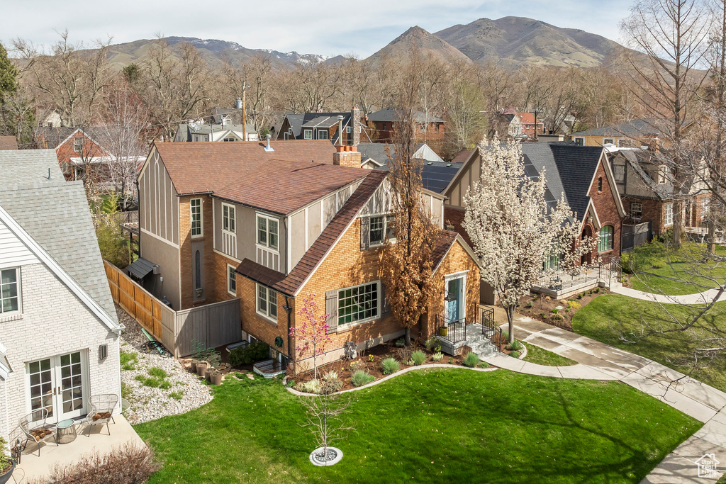 View of front of house with a residential view, a shingled roof, a front lawn, a mountain view, and french doors