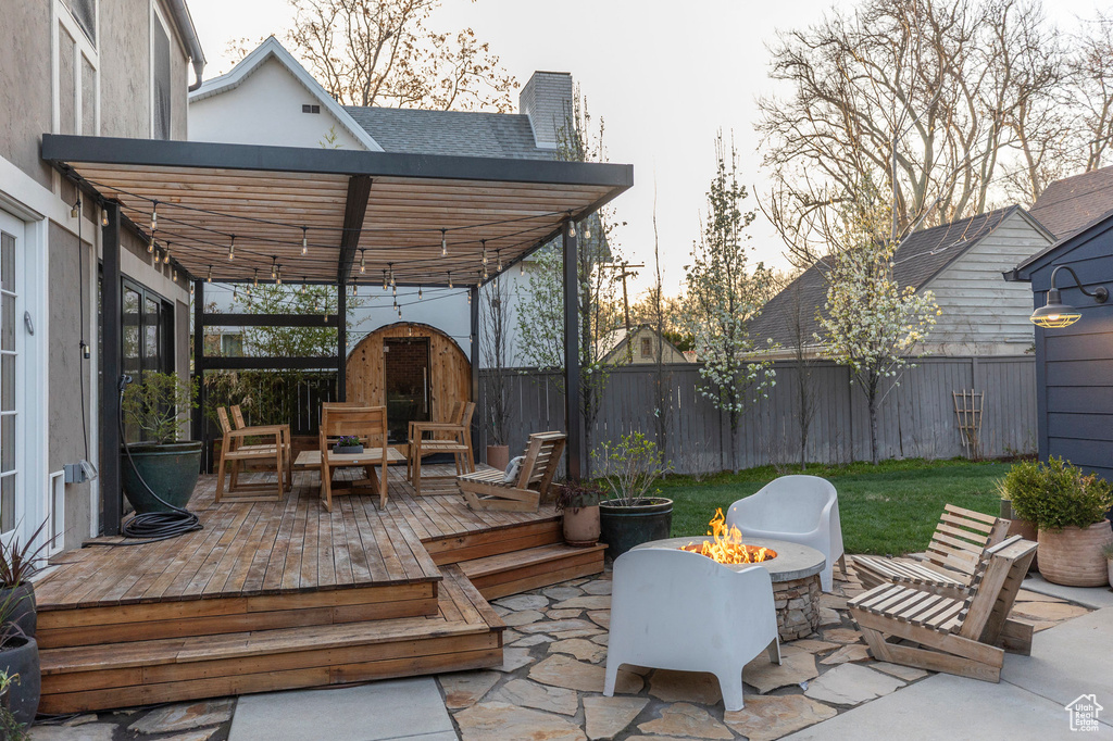View of patio with a fenced backyard, an outdoor fire pit, and a wooden deck