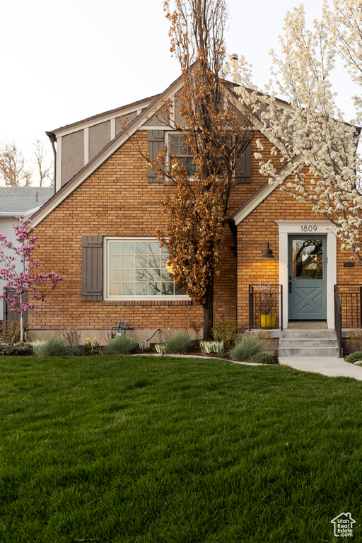 View of front of house featuring brick siding and a front yard