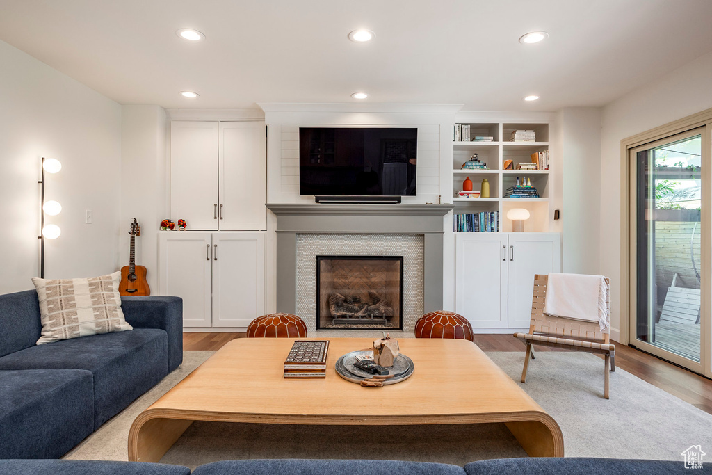 Living room featuring wood finished floors, recessed lighting, and a fireplace