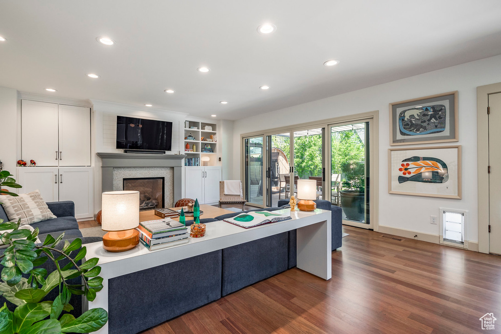 Living area with wood finished floors, recessed lighting, and a glass covered fireplace