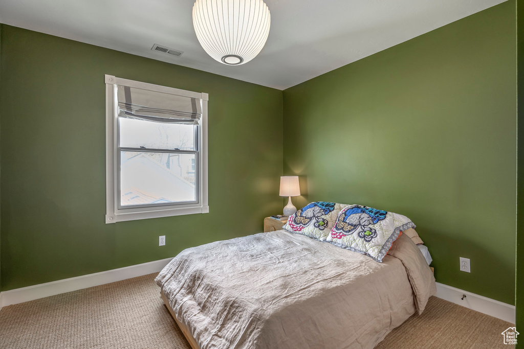 Bedroom with carpet floors, baseboards, and visible vents