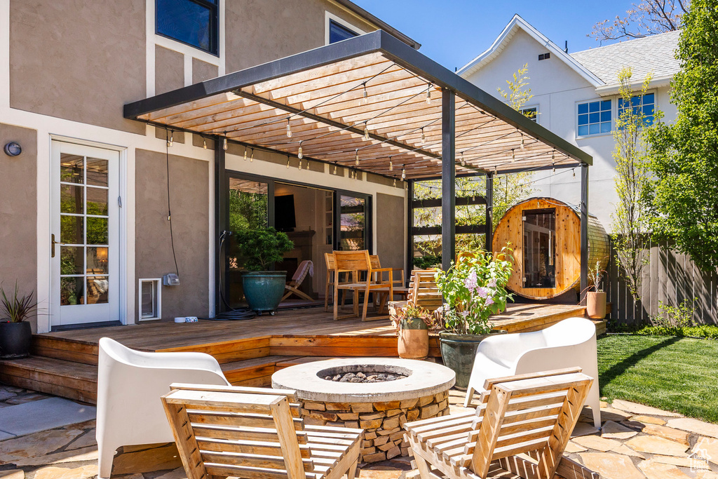 View of patio / terrace with an outdoor fire pit, a pergola, a deck, and a storage shed