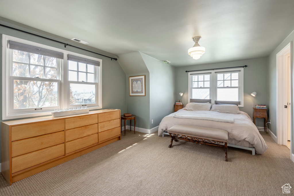 Bedroom with baseboards, multiple windows, light carpet, and lofted ceiling