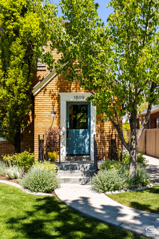 Doorway to property with fence and brick siding