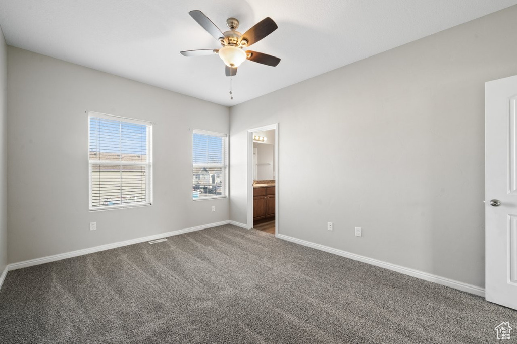 Unfurnished bedroom featuring carpet, baseboards, connected bathroom, and ceiling fan