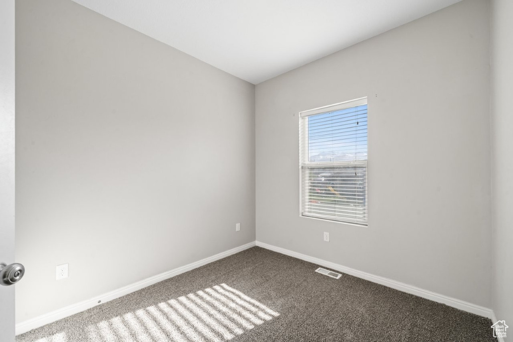 Spare room featuring baseboards, carpet, and visible vents