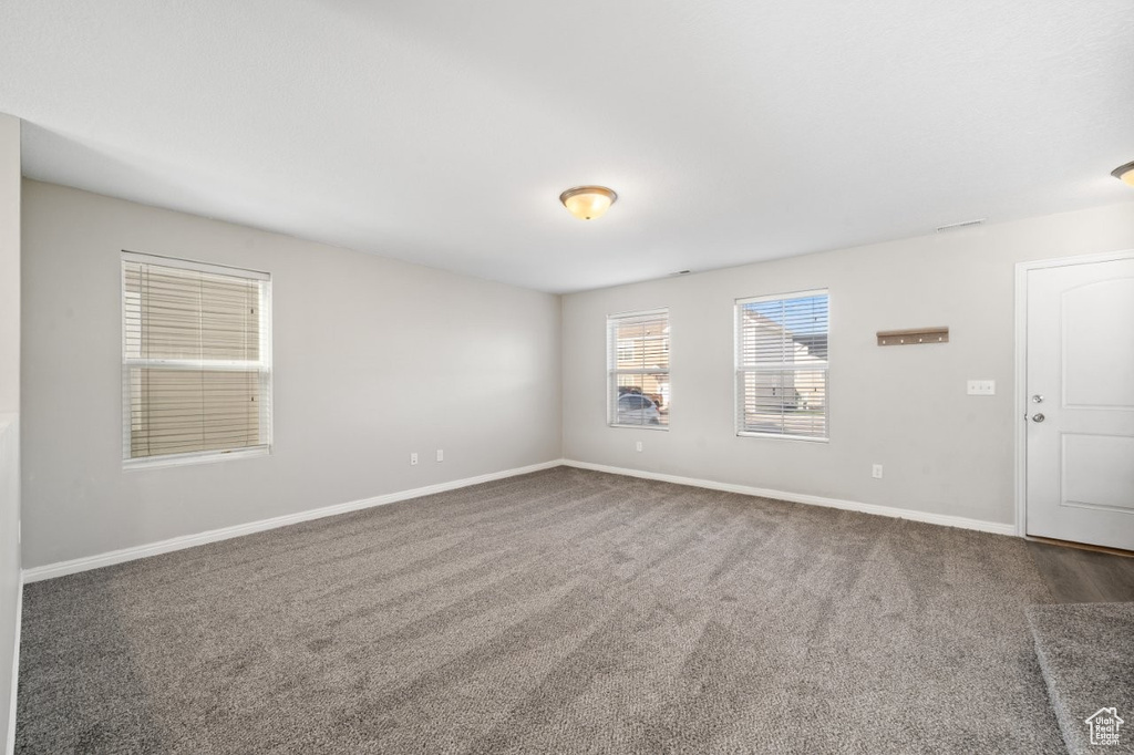 Carpeted spare room with baseboards
