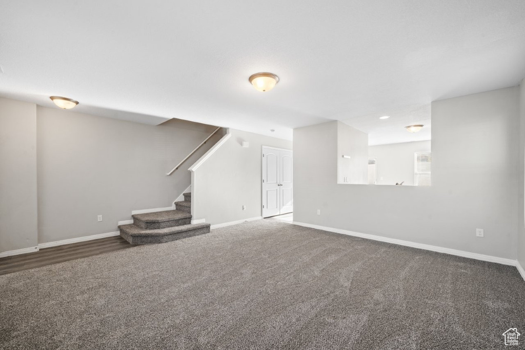Basement with carpet flooring, baseboards, and stairway