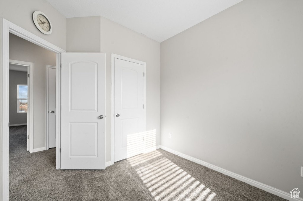 Unfurnished bedroom with carpet floors and baseboards