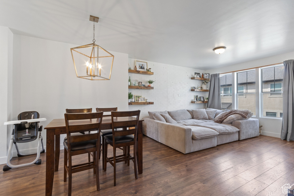 Dining space with a chandelier, dark wood-style floors, and baseboards