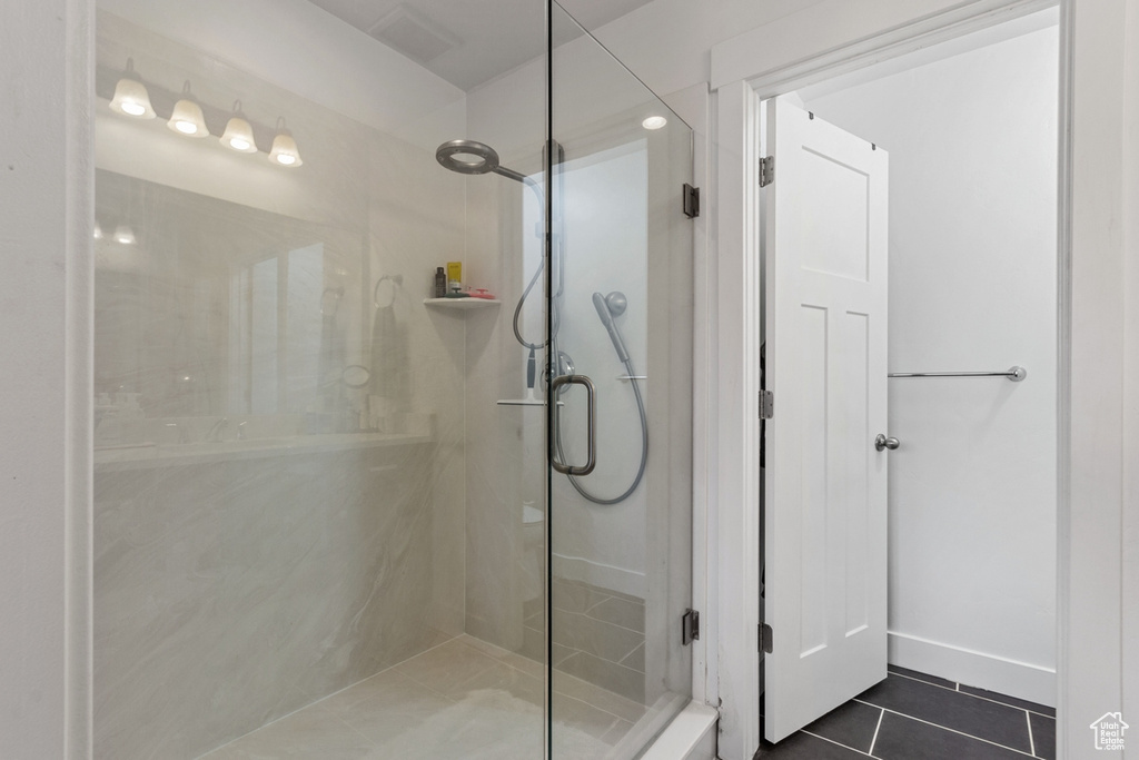 Bathroom with tile patterned floors and a shower stall