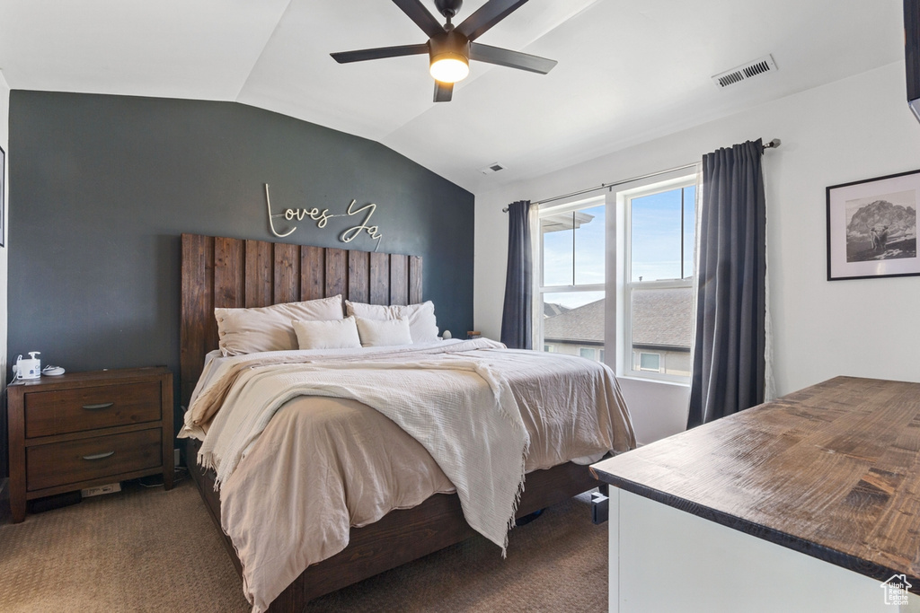 Bedroom featuring dark carpet, lofted ceiling, and ceiling fan