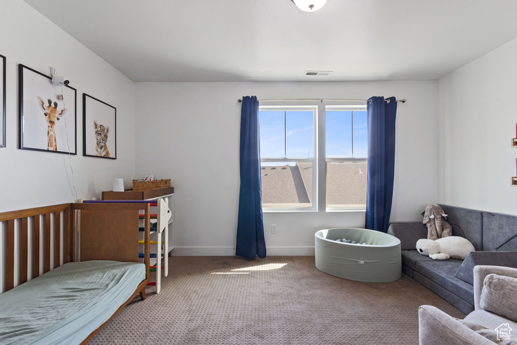 Bedroom featuring carpet and baseboards