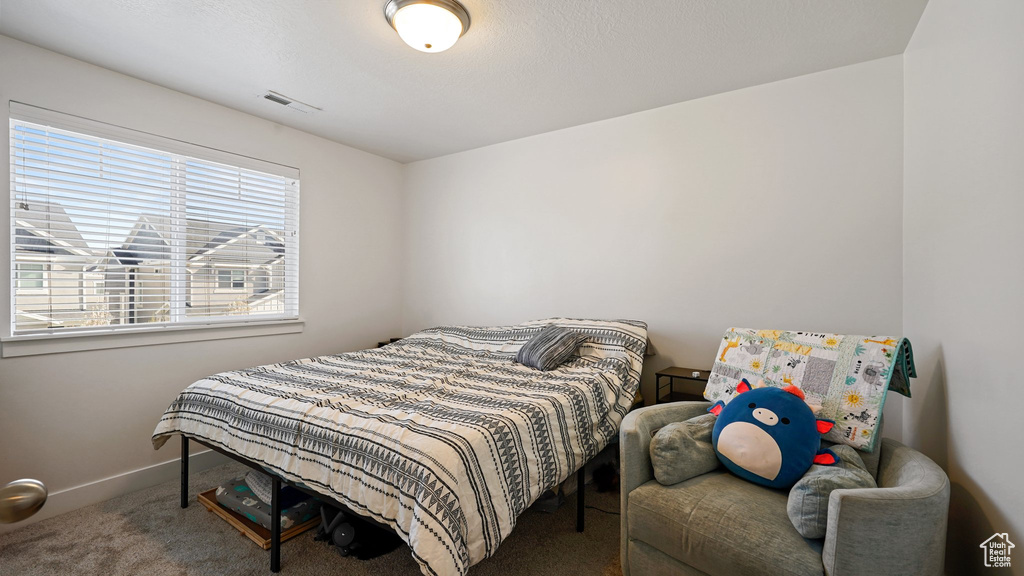 Carpeted bedroom featuring visible vents and baseboards