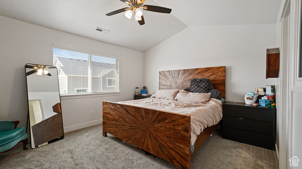 Carpeted bedroom featuring visible vents, baseboards, vaulted ceiling, and ceiling fan