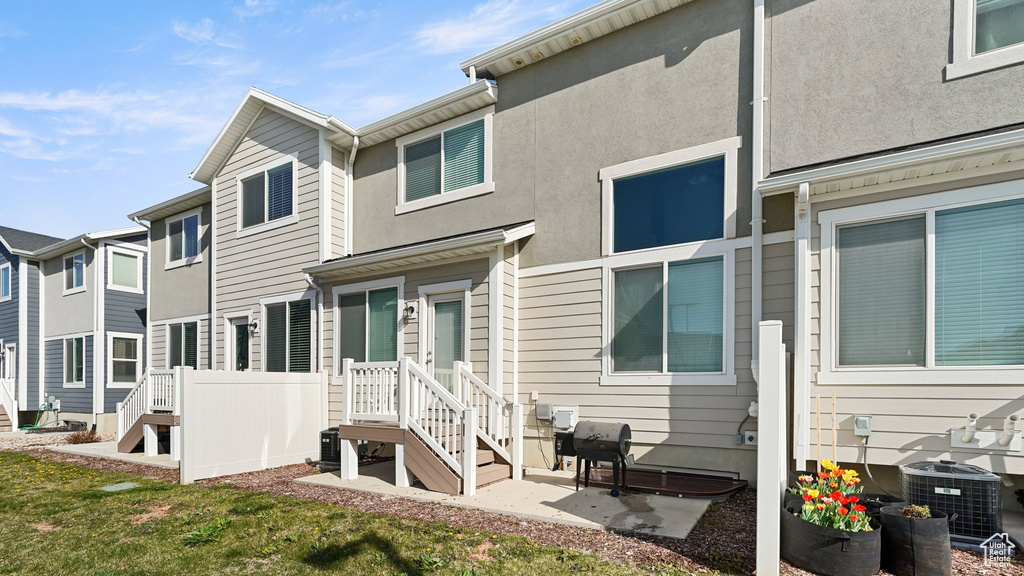 Rear view of house featuring stucco siding and central AC unit