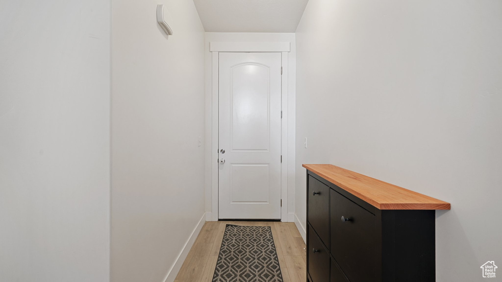 Doorway with light wood-style floors and baseboards