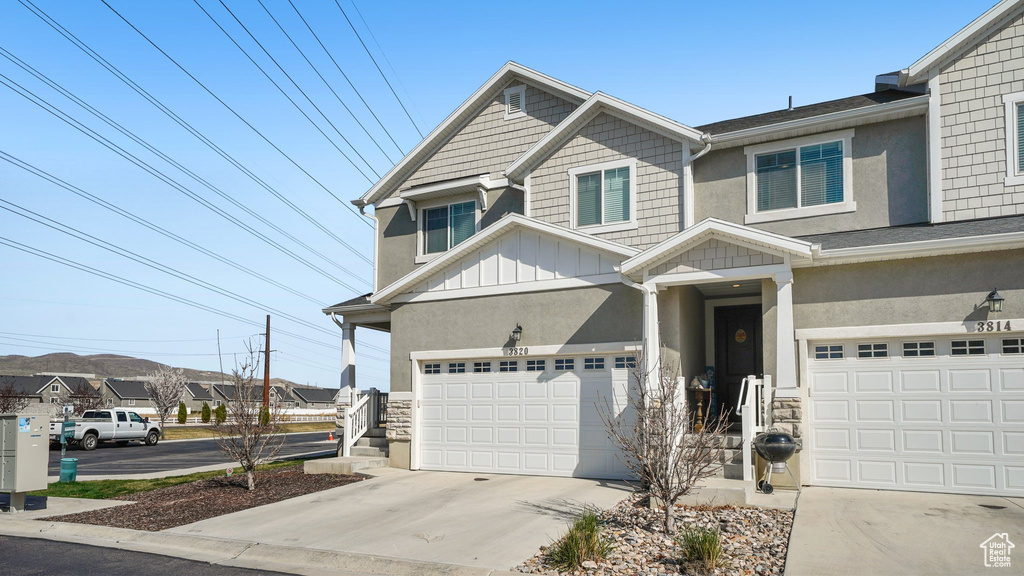 View of front of home featuring a garage, stucco siding, board and batten siding, and concrete driveway