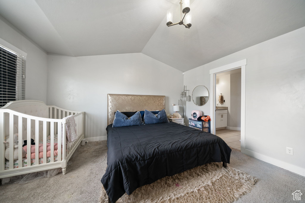 Bedroom with baseboards, connected bathroom, lofted ceiling, and carpet floors