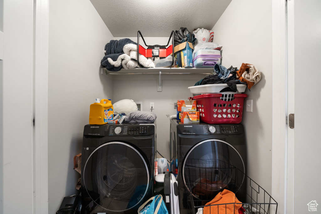 Laundry area featuring separate washer and dryer, laundry area, and a textured ceiling