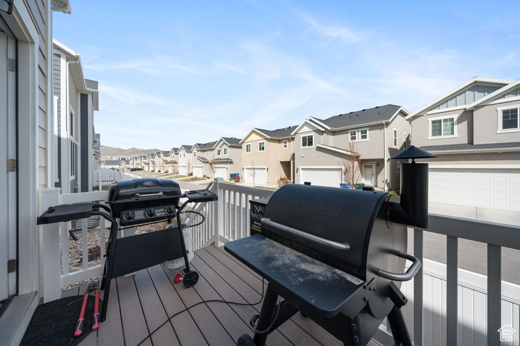 Wooden deck featuring a grill and a residential view