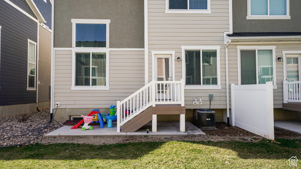Entrance to property with a yard, a patio area, and central AC
