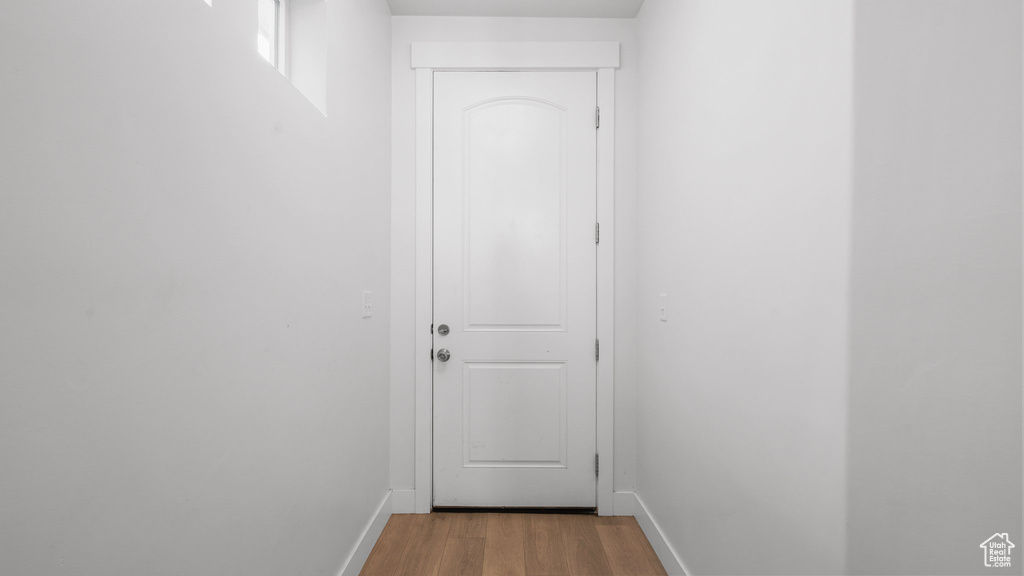 Doorway featuring baseboards and wood finished floors