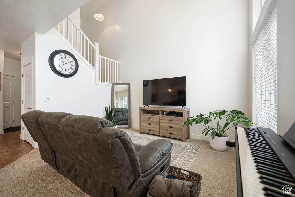 Living room with carpet, a high ceiling, and baseboards