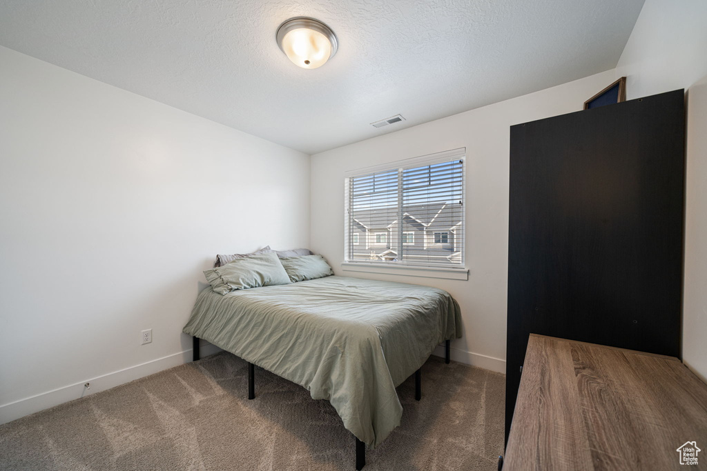 Bedroom with visible vents, baseboards, and carpet