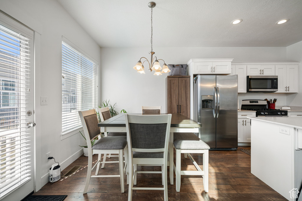 Dining area with a chandelier, dark wood-style flooring, baseboards, and recessed lighting