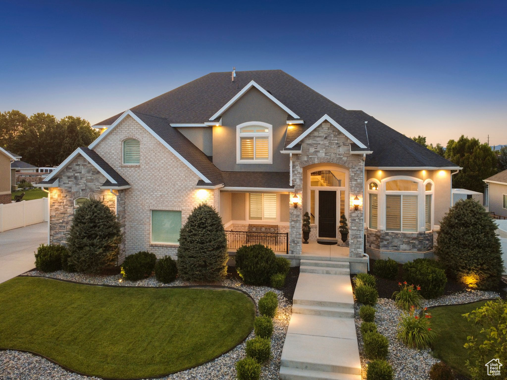 Craftsman-style home featuring stone siding, stucco siding, a porch, and a shingled roof