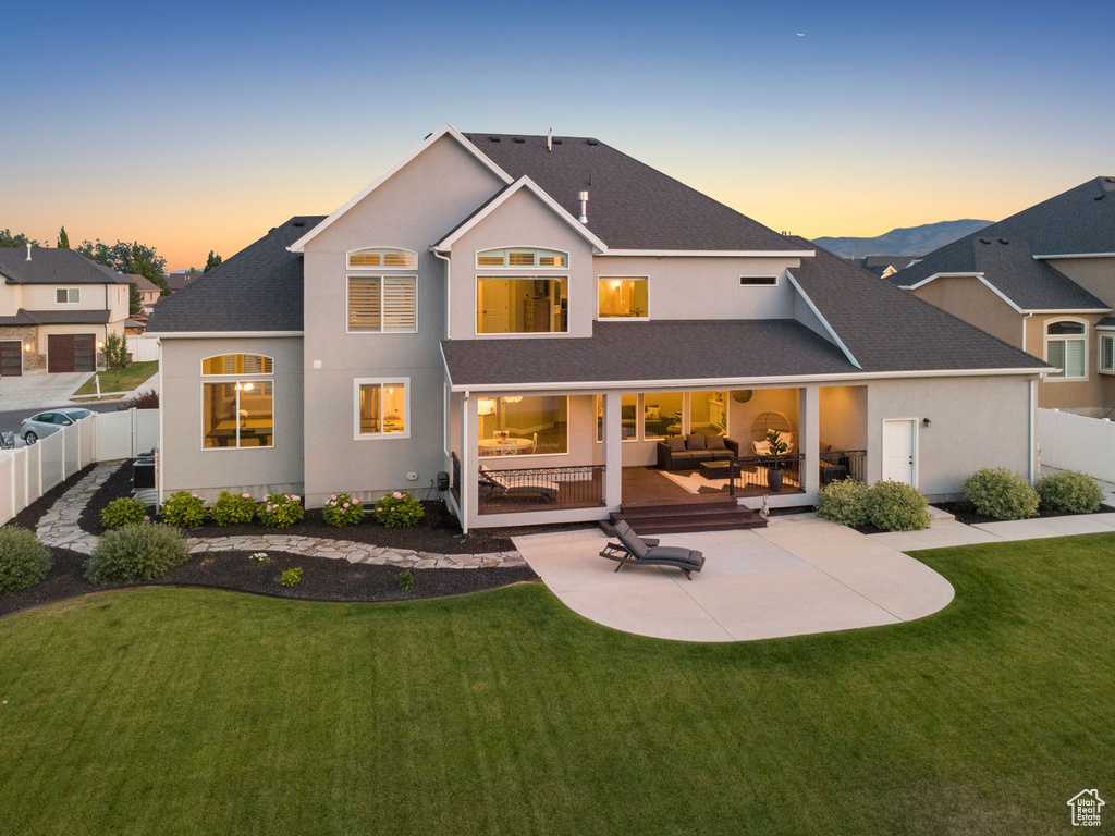 Rear view of property featuring a patio area, a fenced backyard, roof with shingles, and an outdoor hangout area