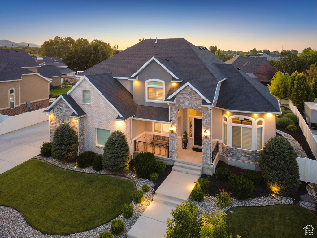 Craftsman-style home featuring stone siding, covered porch, and stucco siding
