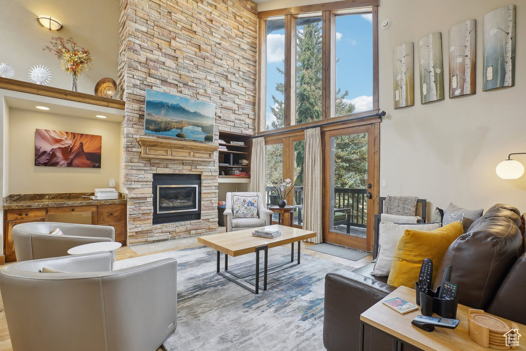 Living room featuring a high ceiling and a stone fireplace