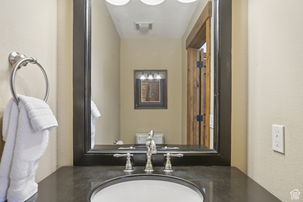 Bathroom with a sink, visible vents, and toilet