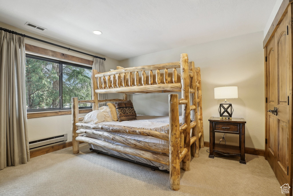 Bedroom featuring light colored carpet, visible vents, recessed lighting, a baseboard heating unit, and baseboards