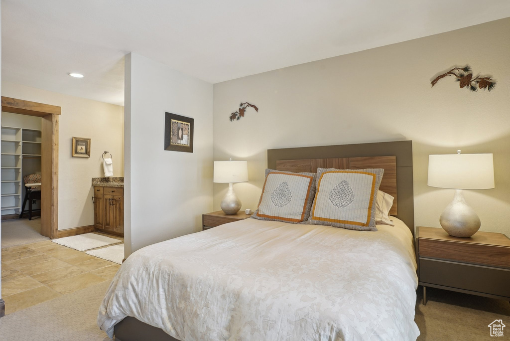 Bedroom featuring a closet, ensuite bath, a spacious closet, and baseboards