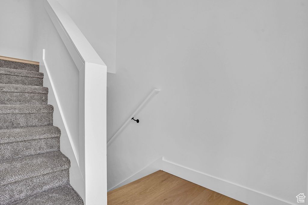 Stairway featuring wood finished floors