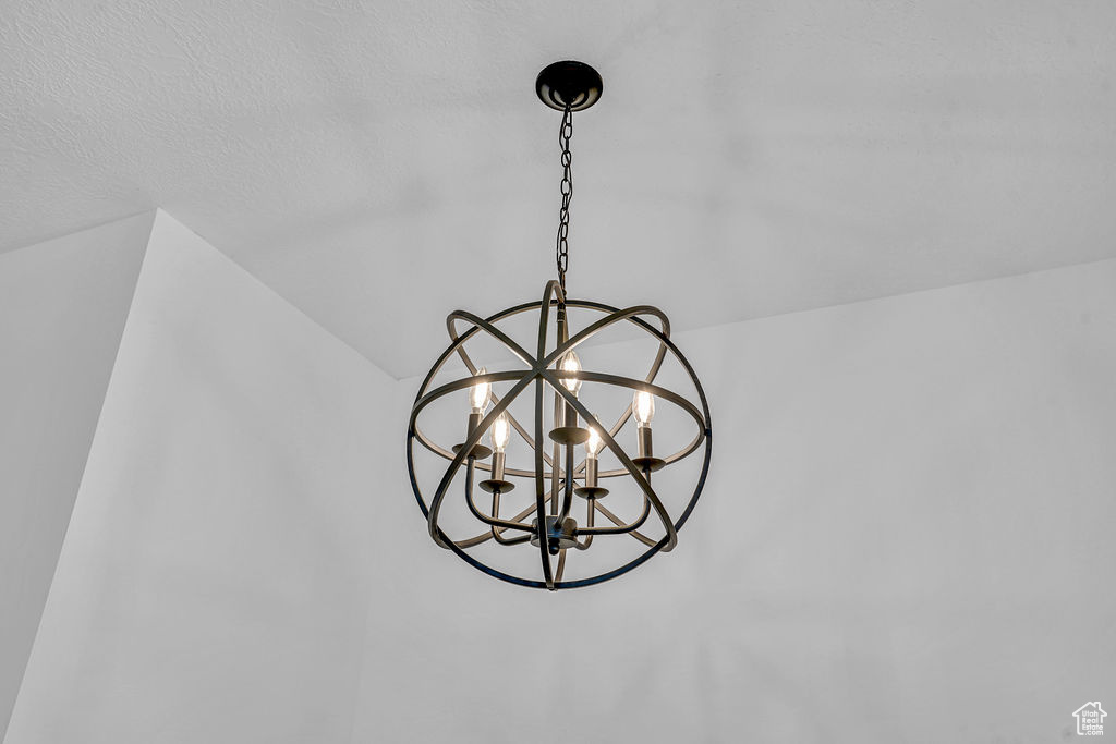 Details featuring a textured ceiling and an inviting chandelier