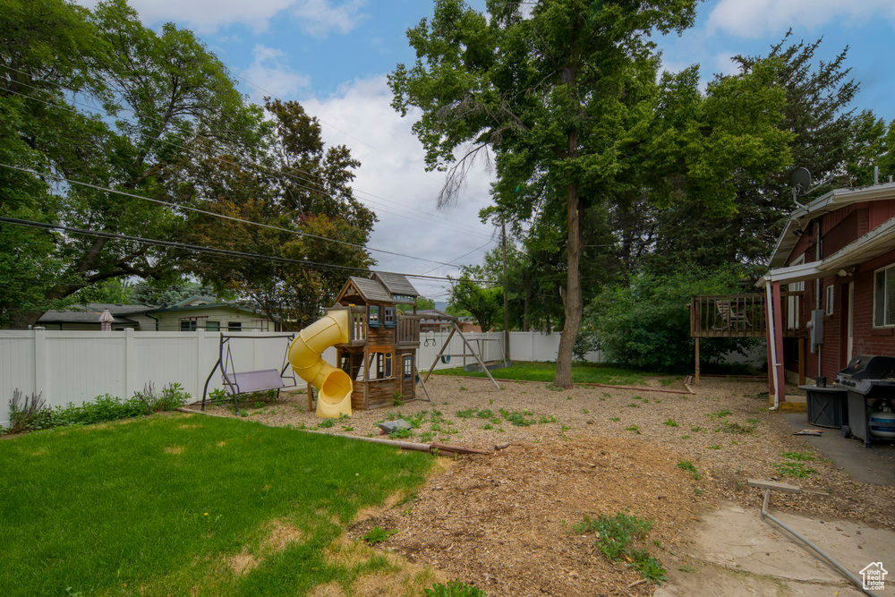 View of yard featuring a playground and a wooden deck