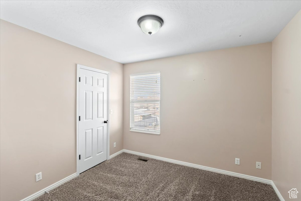 Carpeted empty room with baseboards
