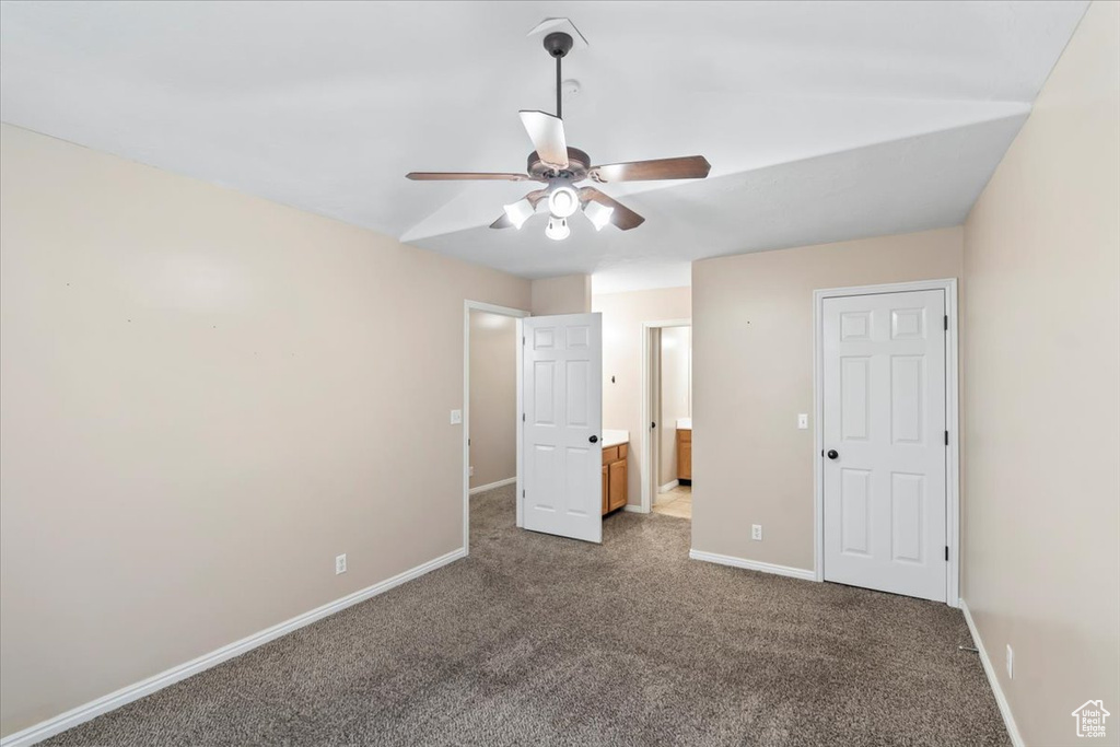 Unfurnished bedroom featuring ensuite bath, baseboards, and carpet