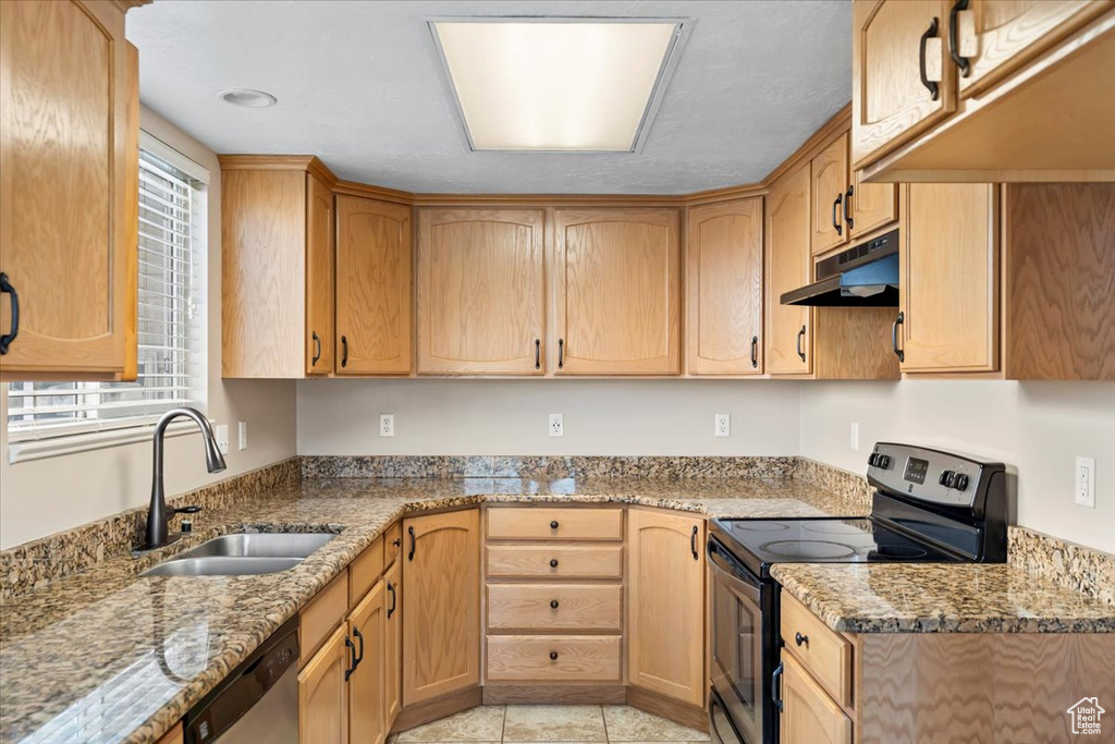 Kitchen featuring under cabinet range hood, light stone countertops, a sink, and appliances with stainless steel finishes