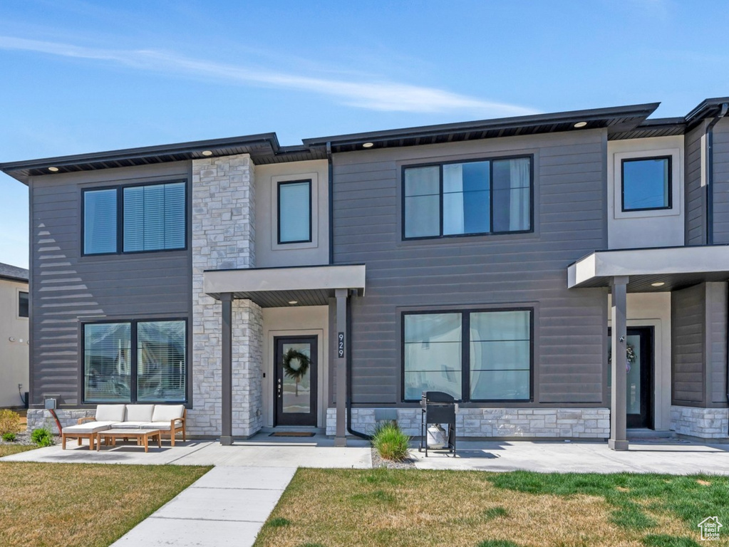 View of front of home with a front yard and stone siding
