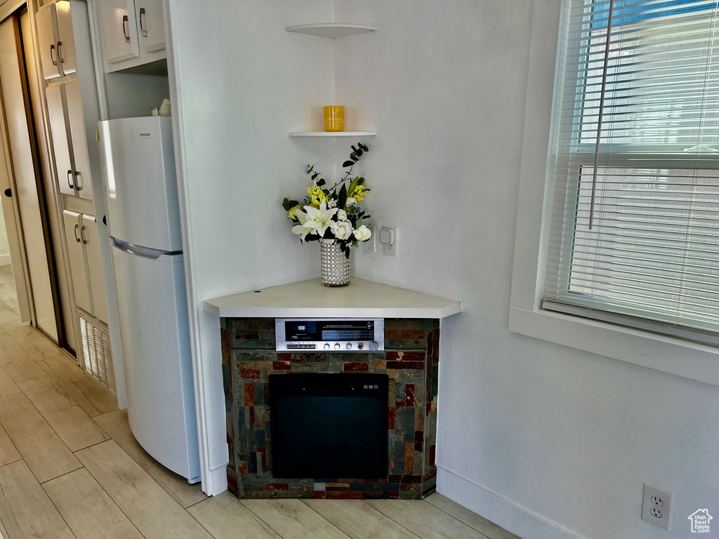 Details featuring open shelves, light countertops, freestanding refrigerator, white cabinetry, and wood finish floors