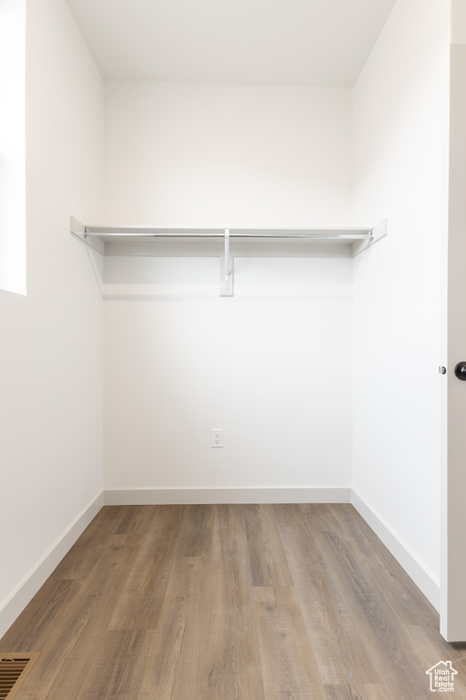 Walk in closet featuring wood finished floors and visible vents